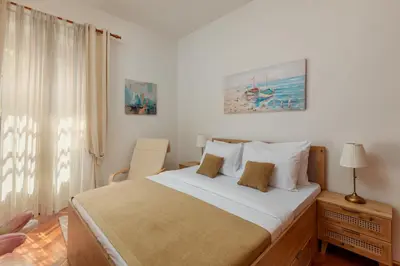 a bedroom with a large bed and a window at Epoha Apartment in Kotor