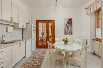 a kitchen with a white table and chairs and a sink at Epoha Apartment in Kotor