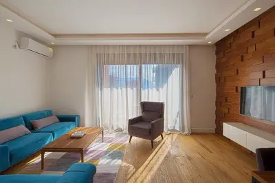 a living room with a blue couch and a television at Modern home in the city center in Budva