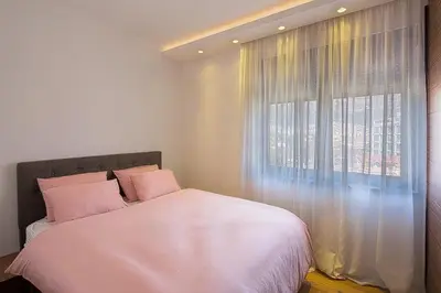 a bedroom with a bed and a large window at Modern home in the city center in Budva