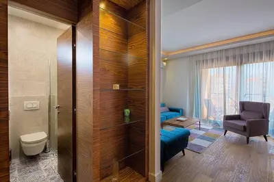 a bathroom with a toilet and a chair in a room at Modern home in the city center in Budva