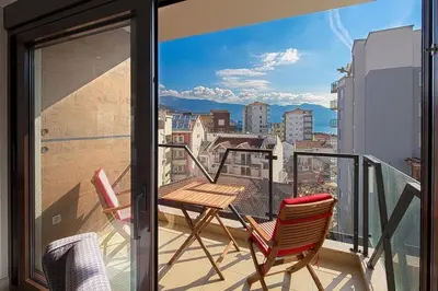 a balcony with two chairs and a view of a city at Modern home in the city center in Budva