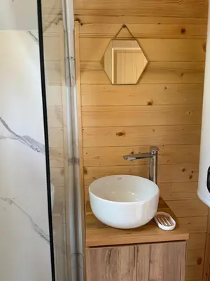 a bathroom with a bowl sink on a wooden wall at Gorska Dolina in Ivanova Korita