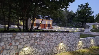 a stone wall with lights in front of a house at Gorska Dolina in Ivanova Korita
