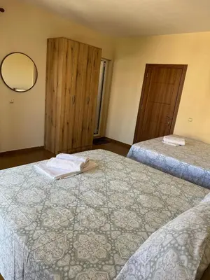 a hotel room with two beds and a mirror at Apartments Family Ibrahimi in Ulcinj