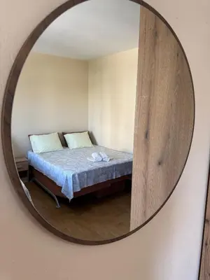 a mirror reflecting a bed in a room at Apartments Family Ibrahimi in Ulcinj