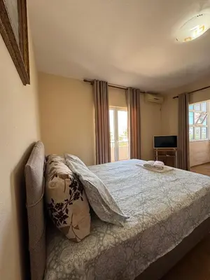 a bedroom with a bed with a blanket on it at Apartments Family Ibrahimi in Ulcinj
