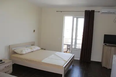 a bedroom with a bed and a large window at Apartments Family Ibrahimi in Ulcinj