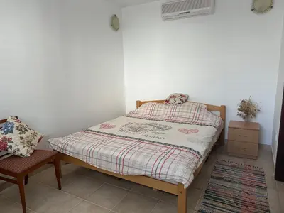 a small bedroom with a bed and a chair at Kalina in Bigovo