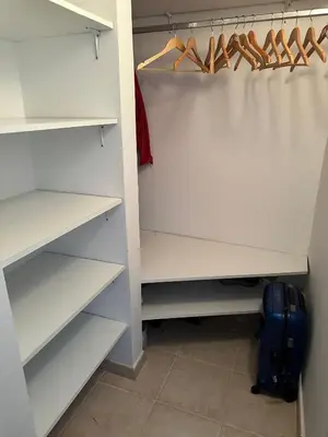 a white closet with shoes and a suitcase at Kalina in Bigovo