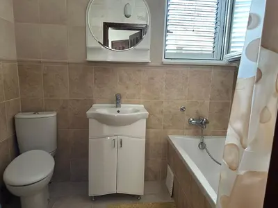 a bathroom with a toilet and a sink and a mirror at Kalina in Bigovo