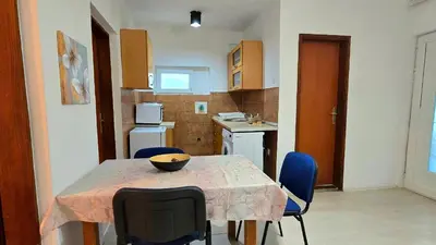 a kitchen with a table and blue chairs in a room at Alpha Casa in Bar