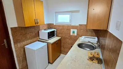 a small kitchen with a sink and a microwave at Alpha Casa in Bar