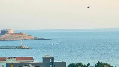 a bird is flying over the ocean with a lighthouse at Alpha Casa in Bar