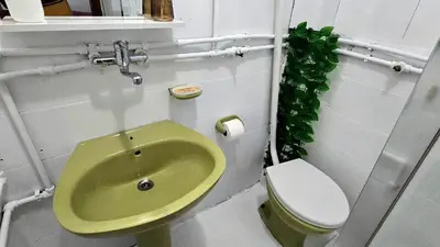 a bathroom with a green sink and a toilet at Alpha Casa in Bar