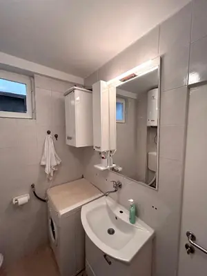 a white bathroom with a sink and a mirror at Sunset Bay Budva in Budva