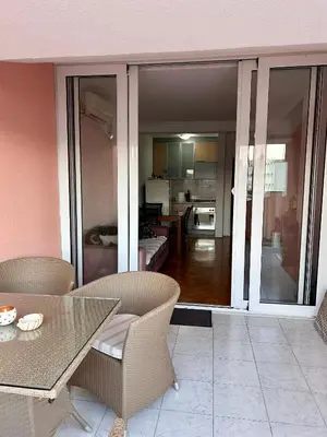 a room with a table and chairs and a kitchen at Sunset Bay Budva in Budva