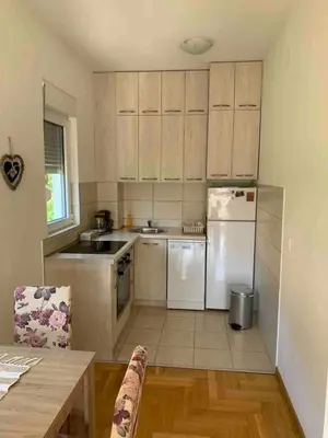 a kitchen with white cabinets and a white refrigerator at Cozy Apartment with Private Garage - Walk to City Center in Budva