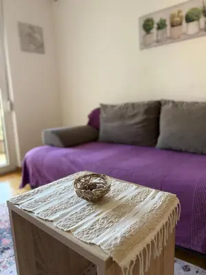 a living room with a purple couch and a table at Cozy Apartment with Private Garage - Walk to City Center in Budva
