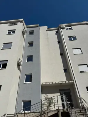 a tall apartment building with a blue sky in the background at Cozy Apartment with Private Garage - Walk to City Center in Budva