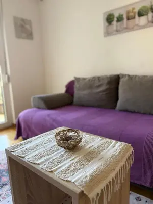 a living room with a purple couch and a table at Cozy Apartment with Private Garage - Walk to City Center in Budva