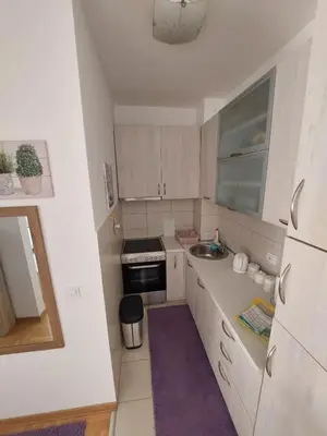 a small kitchen with white cabinets and a sink at Cozy Apartment Perfect for Vacation in Budva