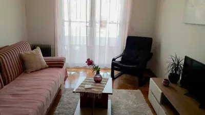 a living room with a couch and a chair at Cozy Apartment Perfect for Vacation in Budva