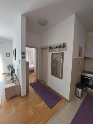 a living room with white walls and wooden floors at Cozy Apartment Perfect for Vacation in Budva
