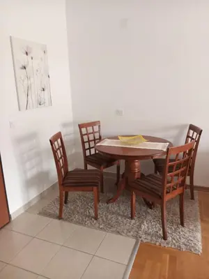 a wooden table with four chairs and a dining room at Cozy Apartment Perfect for Vacation in Budva