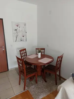 a dining room table with four chairs and a table at Cozy Apartment Perfect for Vacation in Budva