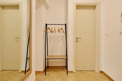 a room with two doors with a chair and a mirror at Vista Mare Apartments in Budva