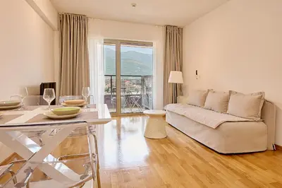 a living room with a couch and a table with wine glasses at Vista Mare Apartments in Budva