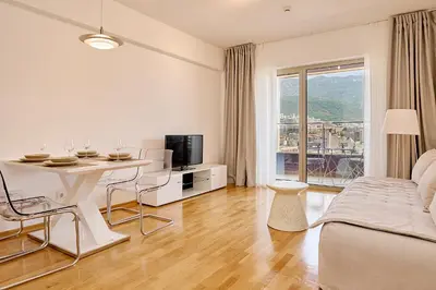 a white living room with a table and a bed at Vista Mare Apartments in Budva