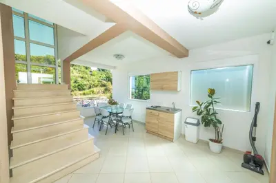 a home with stairs and a dining room with a table at Lida Apartments in Ulcinj