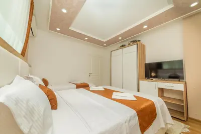 a bedroom with two beds and a flat screen tv at Lida Apartments in Ulcinj