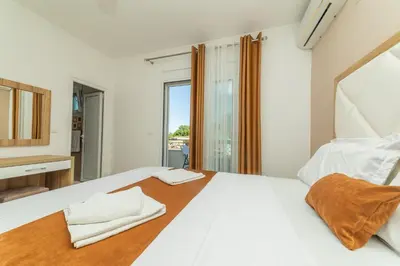 a bedroom with a large white bed with a window at Lida Apartments in Ulcinj