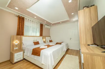 a bedroom with a large bed and a television at Lida Apartments in Ulcinj
