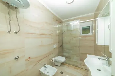 a bathroom with a shower and a toilet and a sink at Lida Apartments in Ulcinj