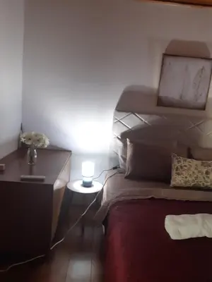 a bedroom with a bed and a dresser with a lamp at Kruce accommodation in Ulcinj