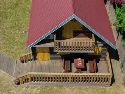 an overhead view of a log cabin with a red roof at Vikendica na obali rijeke Bojane sa velikim dvoristem, parkingom ljetnjom kuhinjom i mjestom za rostilj in Ulcinj