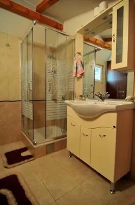 a bathroom with a sink and a shower at Vikendica na obali rijeke Bojane sa velikim dvoristem, parkingom ljetnjom kuhinjom i mjestom za rostilj in Ulcinj