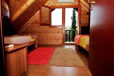 a room with two beds and a red rug at Vikendica na obali rijeke Bojane sa velikim dvoristem, parkingom ljetnjom kuhinjom i mjestom za rostilj in Ulcinj
