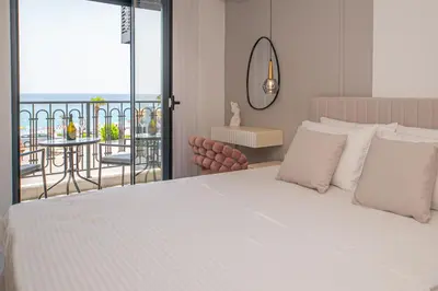 a bedroom with a white bed and a balcony at Apartment Ejna in Dobra Voda