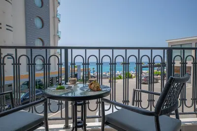 a table and chairs on a balcony with a view of a street at Apartment Ejna in Dobra Voda