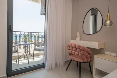 a living room with a chair and a balcony at Apartment Ejna in Dobra Voda