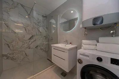 a bathroom with a washing machine and a sink at Apartment Ejna in Dobra Voda