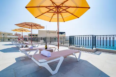 a row of lounge chairs and umbrellas on a patio at Apartment Ejna in Dobra Voda