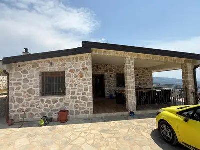 a stone house with a car parked in front of it at Salakovic Country Estate in Bar