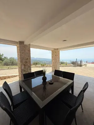 a dining room with a table and chairs and the ocean at Salakovic Country Estate in Bar