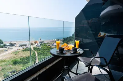 a table with food and orange juice on a balcony at Apartman Katica in Becici